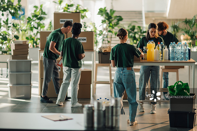 志愿者在纸箱中分类捐赠物品以支持慈善事业图片素材