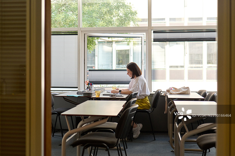 年轻女性在教室里独自学习图片素材