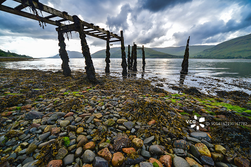 日落时分，苏格兰福特威廉的卵石海滩和古老的码头美景图片素材