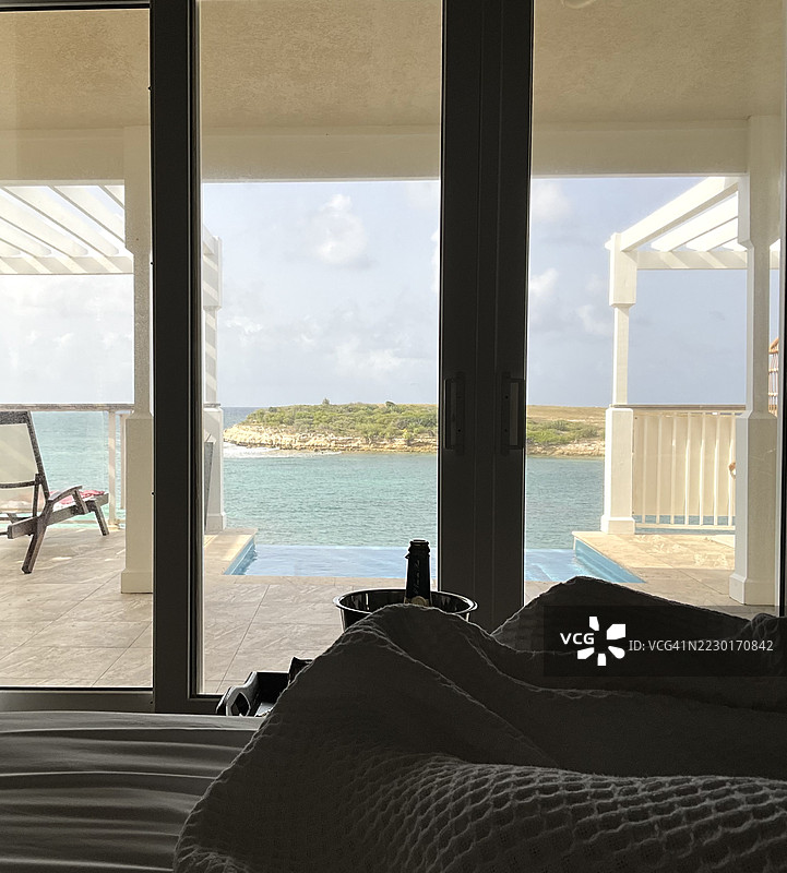卧室内俯瞰海岸风景，旁边放着一瓶香槟图片素材