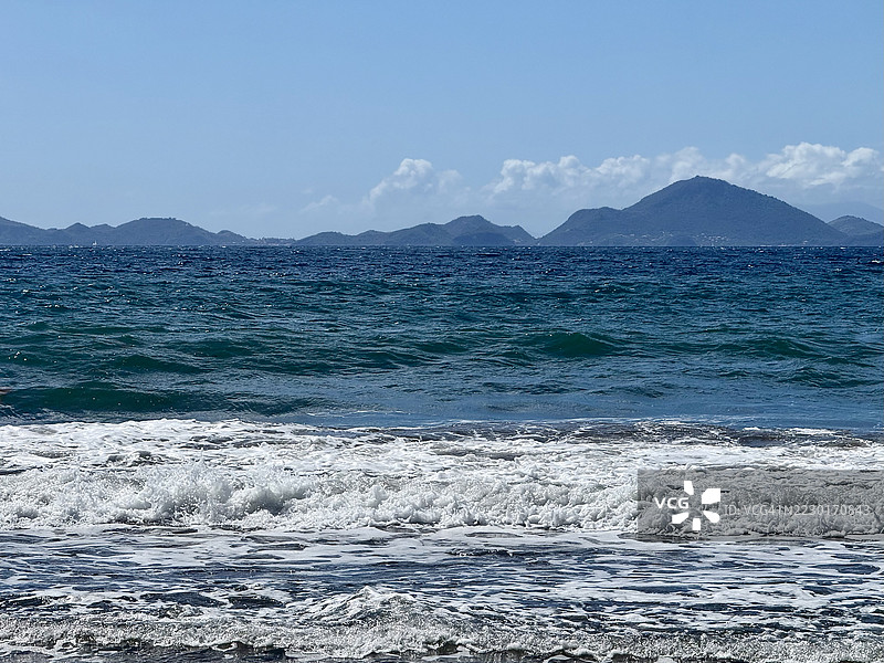 瓜德罗普海岸线的美丽景色，远处有山脉。图片素材