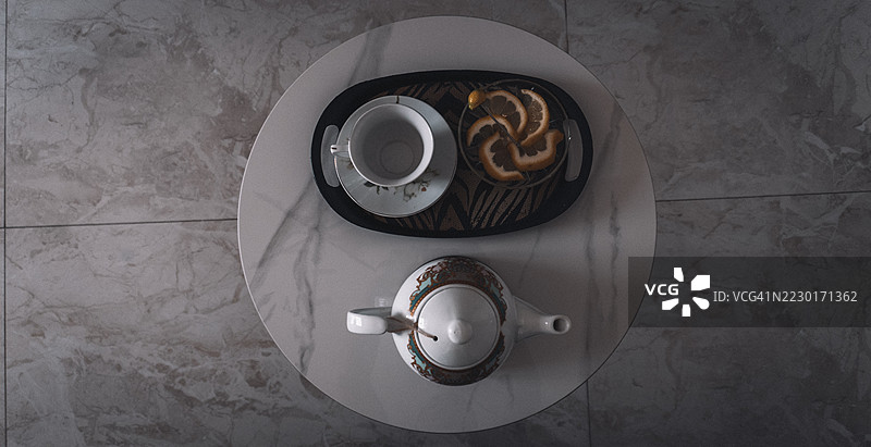 优雅的茶具与切片橙子摆放在大理石桌上图片素材