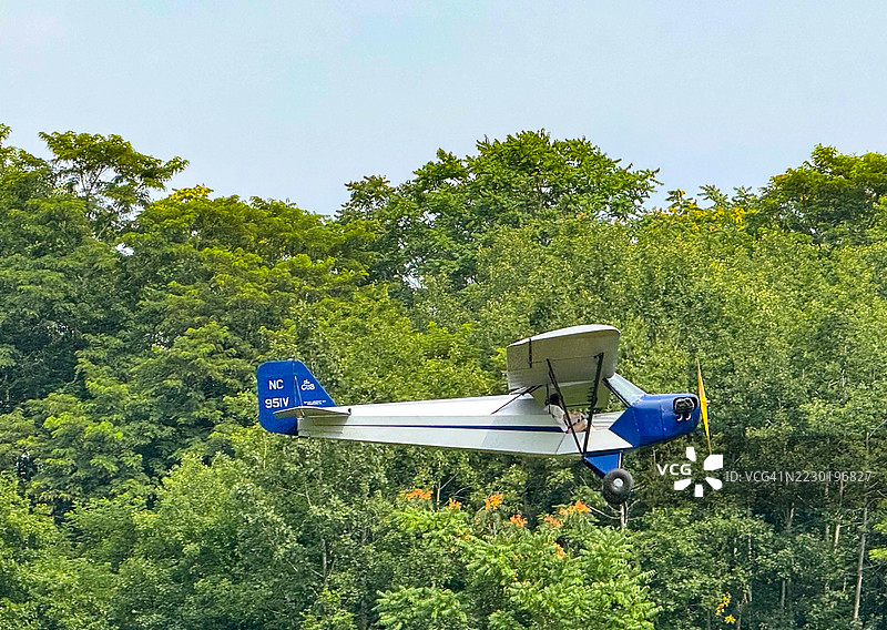 在红钩的老莱茵贝克航空博物馆附近飞行的派珀J-3小鹰飞机图片素材