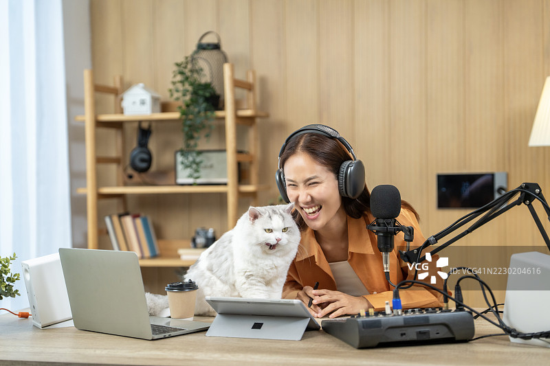 亚洲女性播客主持人与她的猫一起直播图片素材