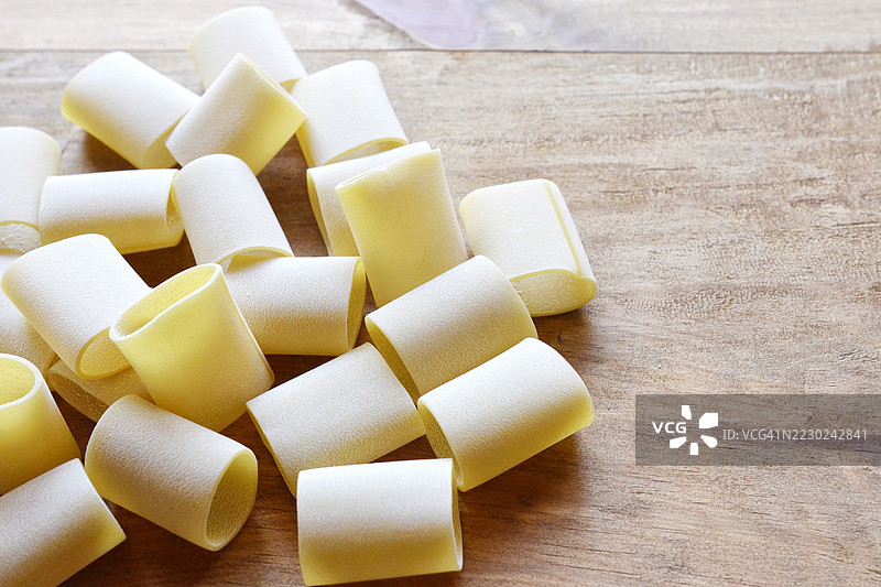 木质背景上的意大利粗面条（Schiaffoni）用杜伦小麦粗面粉制成图片素材