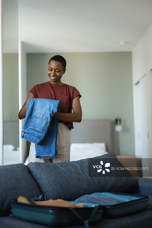 年轻女性在酒店房间里打包行李。图片素材