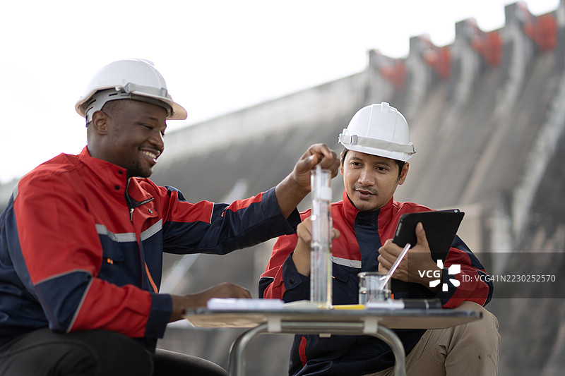 一位环保主义者和一位工程师在大坝上共同工作。图片素材