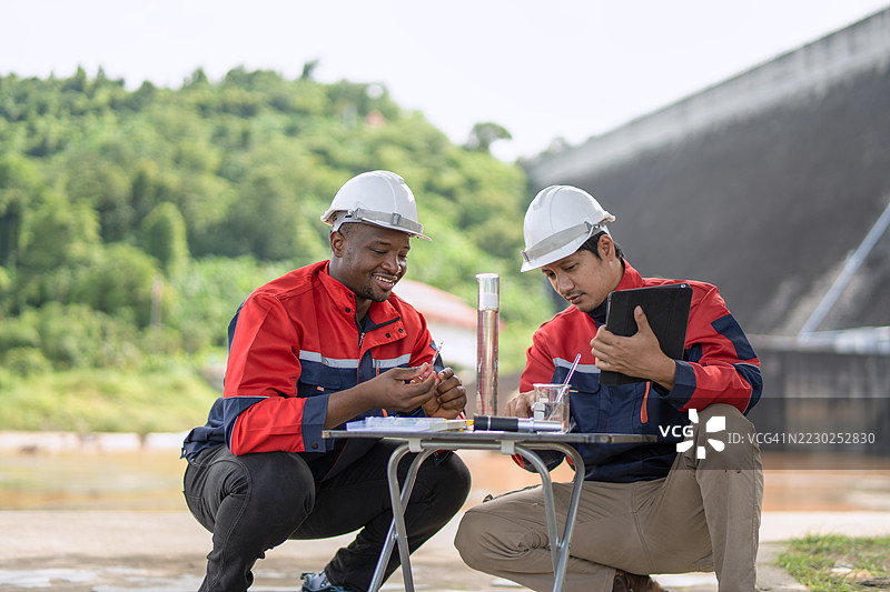 一位环保主义者和一位工程师在大坝上共同工作。图片素材
