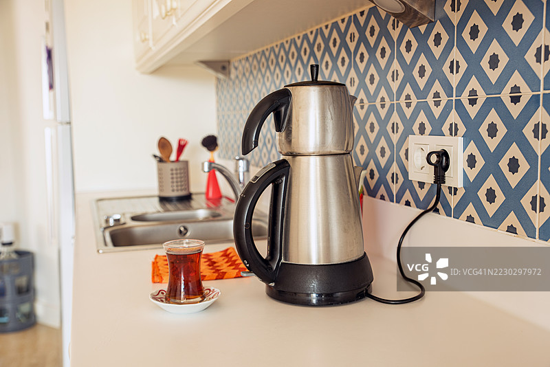 厨房台面上的水壶和满满的茶杯图片素材