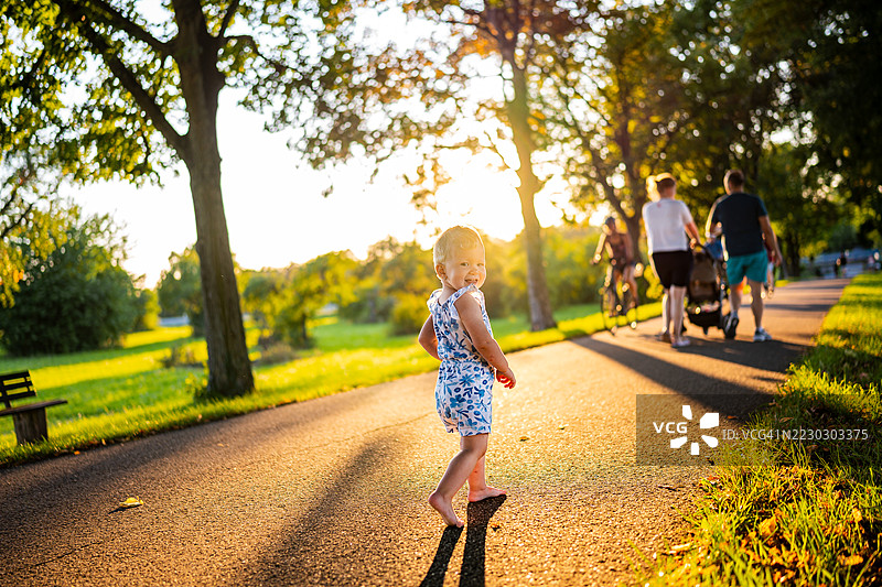 幼儿在公园散步时对着镜头微笑图片素材