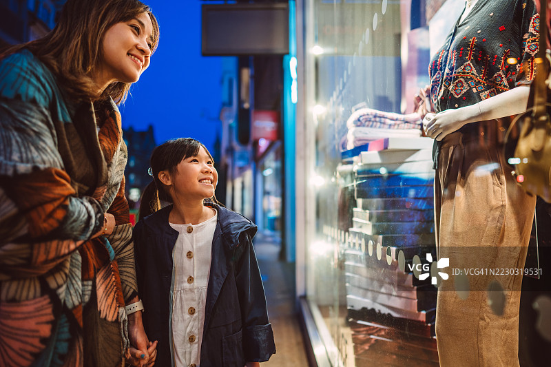 母女俩在夜晚一起逛街购物图片素材