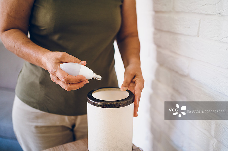 女人更换灯泡图片素材