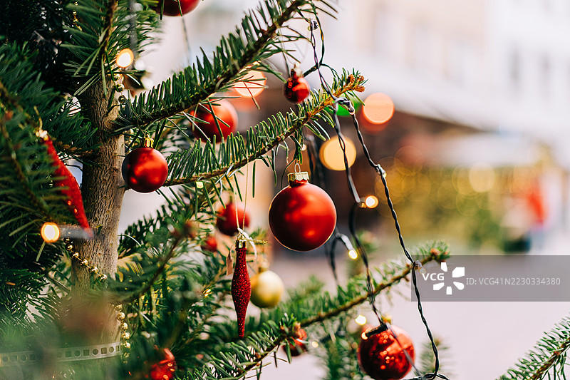聚焦于美丽的圣诞树，装饰着红色饰品和节日灯光图片素材
