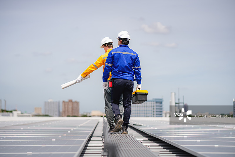 工程师和技术人员正在检查工厂屋顶太阳能电池板的安装，可再生能源，清洁能源图片素材