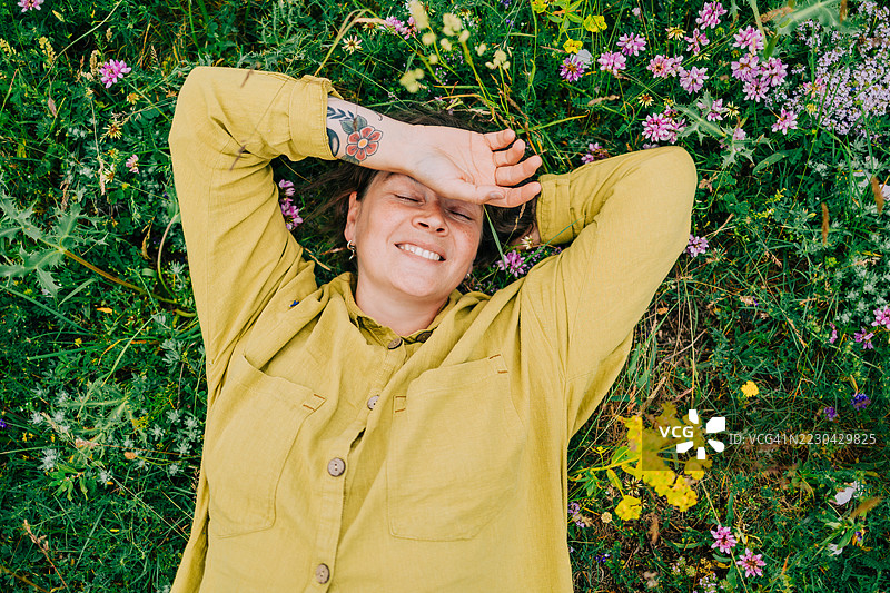 宁静的女人躺在草地上享受大自然图片素材