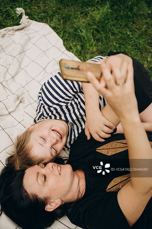 母亲和患有唐氏综合症的儿子在公园自拍图片素材