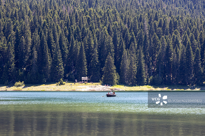 黑湖上的风景，游客们在杜米托尔国家公园（扎布利亚克，黑山，欧洲）划着小桨船图片素材