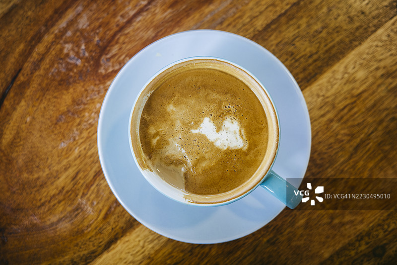 高角度视图的咖啡杯放在木桌上图片素材