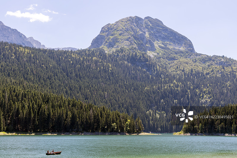 黑湖风景,游客在杜米托尔国家公园(扎布利亚克,黑山,欧洲)的黑湖上划着小桨船图片素材