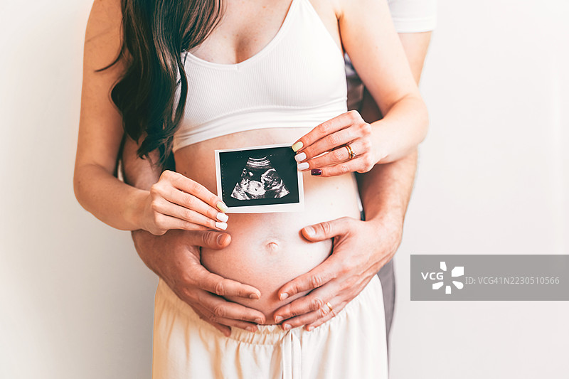 怀孕期间，夫妻展示超声波照片图片素材