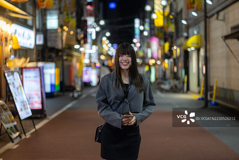 年轻女商人在日本居酒屋街道上的肖像图片素材
