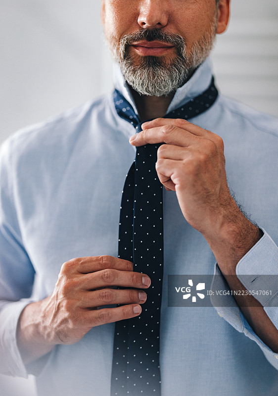 男士在职业装中调整领带准备上班图片素材
