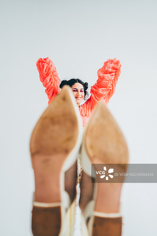 低角度广角镜头拍摄了一位女性，她俯视镜头，表情大胆而自信。图片素材