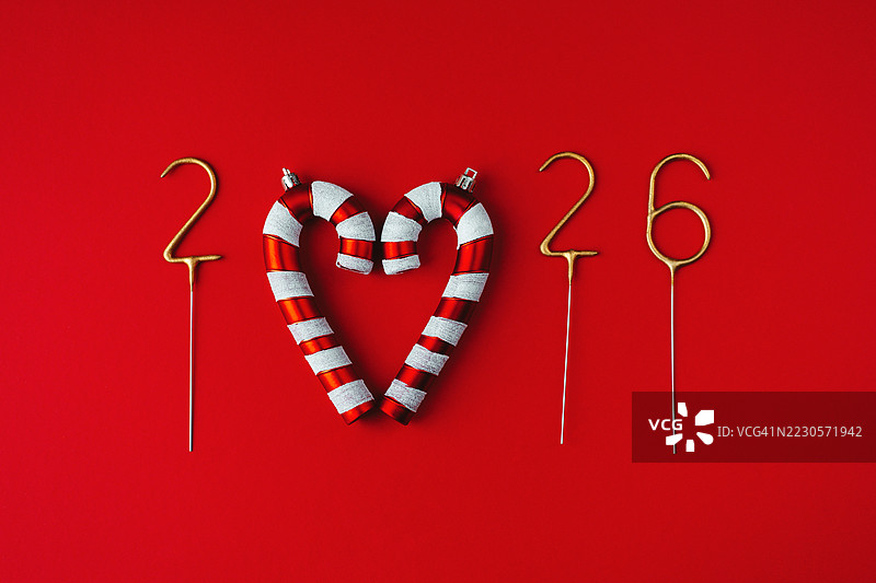 2026年由金色烟花和糖果手杖组成，背景为红色。图片素材