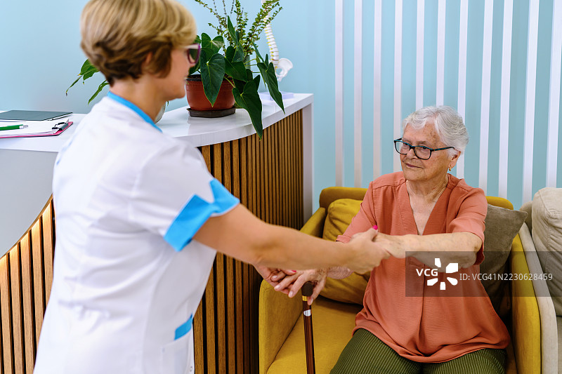 女医生在医院帮助老年女性站起来图片素材
