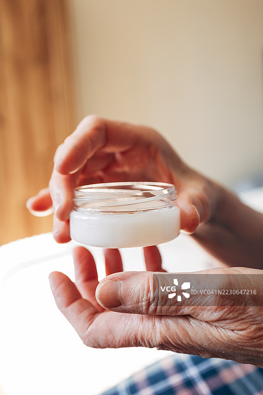老年女性涂抹保湿霜来护理肌肤图片素材