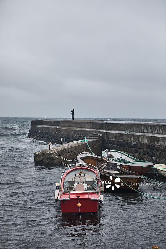 阴天时，船只停靠在码头的海岸港口景象图片素材