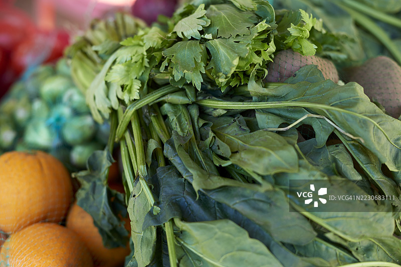 新鲜菠菜、芹菜和其他蔬菜在市场摊位上展示图片素材