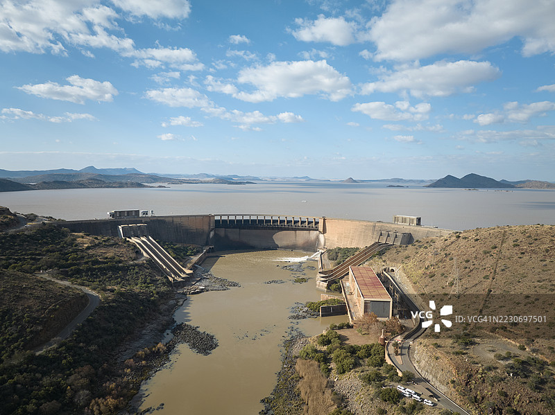 俯瞰大型水坝的航拍镜头，俯视山谷中的流动河流图片素材