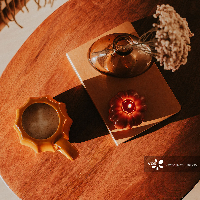 温馨的桌面场景，配有咖啡杯、蜡烛和毛毯图片素材