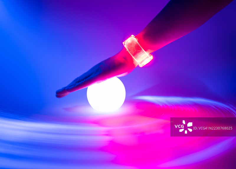 触摸发光球的特写。光纤长时间曝光。人工智能与数据概念。图片素材