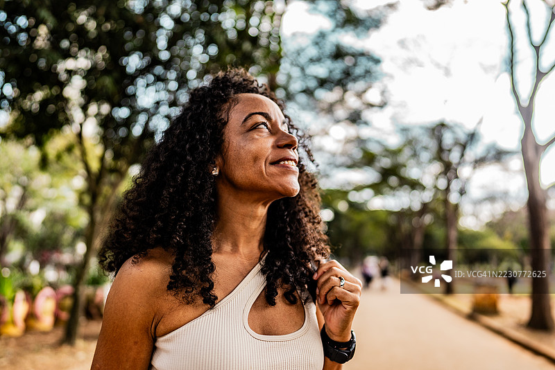 快乐的成熟的女性在公园里望向远方图片素材