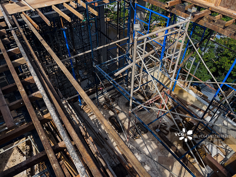 多层建筑的鸟瞰图，正在施工中，密集的钢木脚手架和结构支撑梁。图片素材