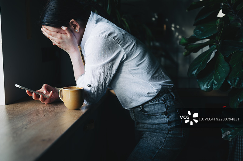 一位女性在打电话时显得很紧张图片素材