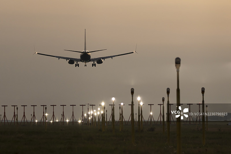 瑞安航空的波音 737 喷气式客机在日落时分于英国埃塞克斯郡伦敦斯坦斯特德机场的飞行降落场景图片素材