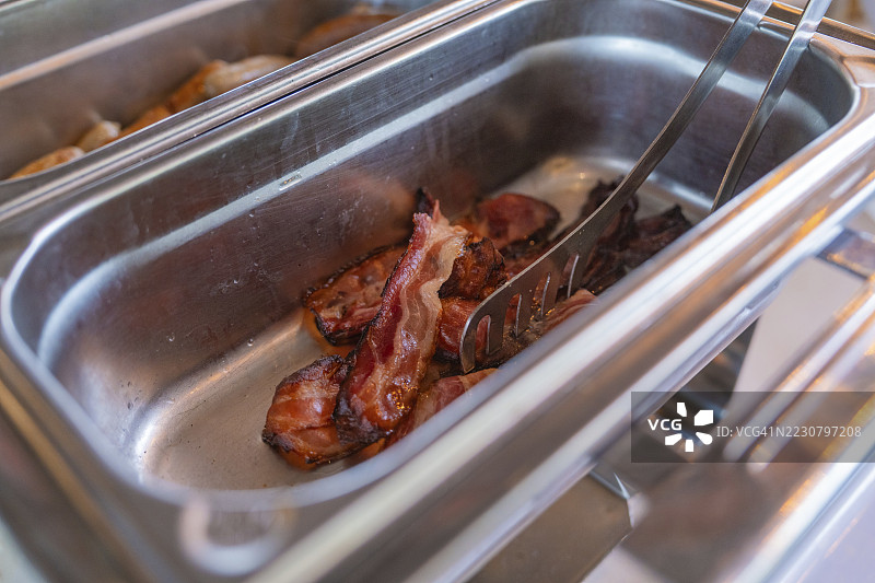 用夹子夹着的煎培根，放在不锈钢容器中，德国博布林根的Schönbuch酿酒厂图片素材