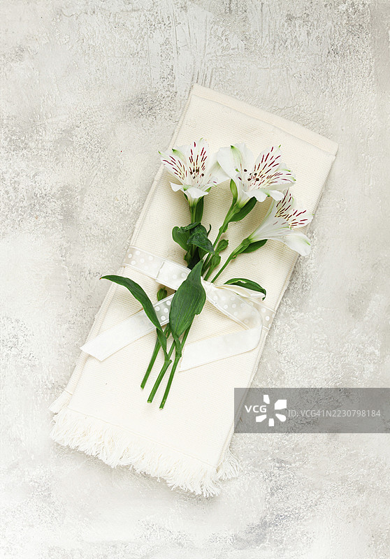 奶油色厨房毛巾，上面有阿尔斯特梅利亚（秘鲁百合），俯视图，概念，装饰，无人。图片素材