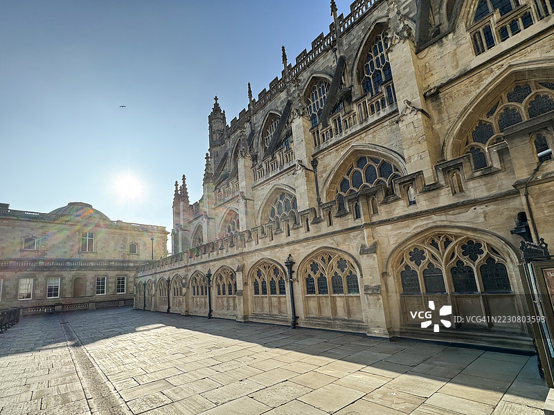 巴斯修道院，英格兰萨默塞特郡巴斯的圣公会教堂，巴斯石材的垂直哥特式建筑，巴斯修道院广场-金斯顿游行，阳光明媚的晴朗蓝天背景图片素材