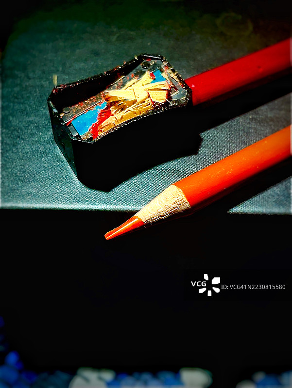 黑色表面上的红色铅笔和削笔器图片素材