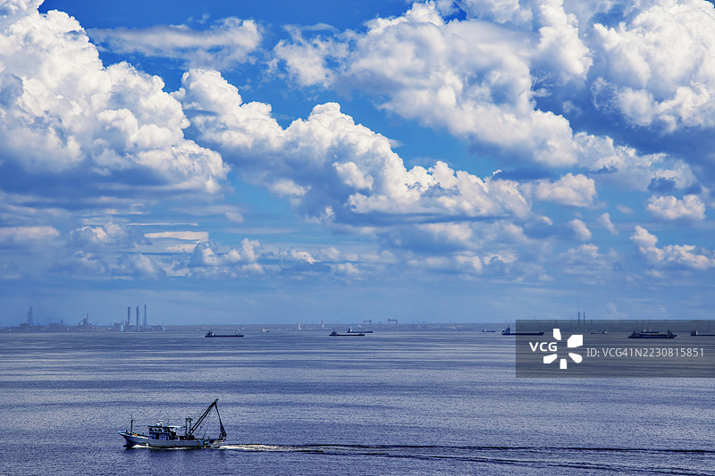 在日本，渔船在戏剧性的多云天空下航行图片素材