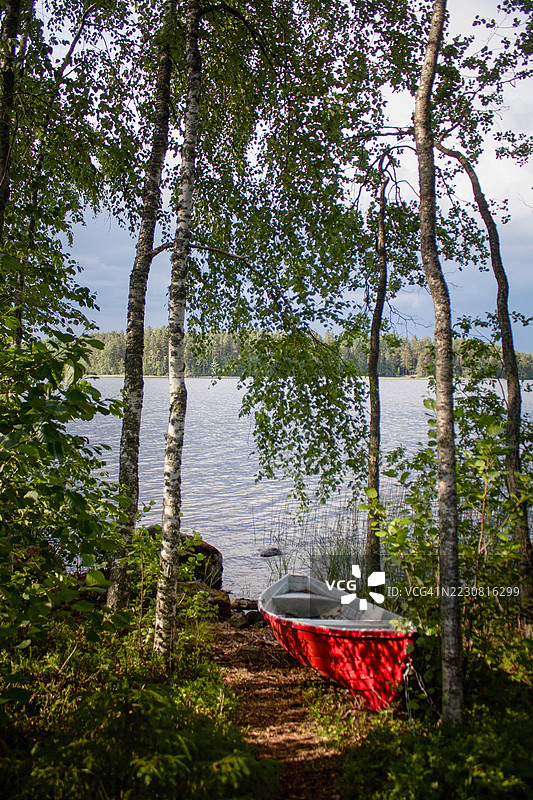 印尼森林湖岸上的红船图片素材