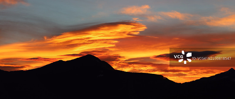 加拿大绚丽橙色日落天空下的山脉剪影图片素材