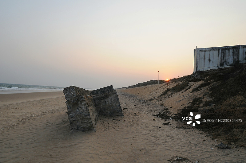 废弃海滩上的日落与遗迹图片素材