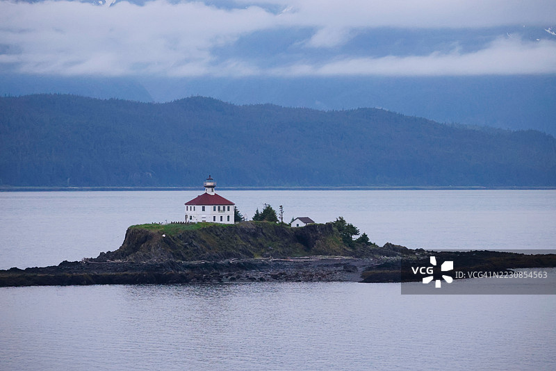 雾海中的岩石岛屿上的灯塔图片素材