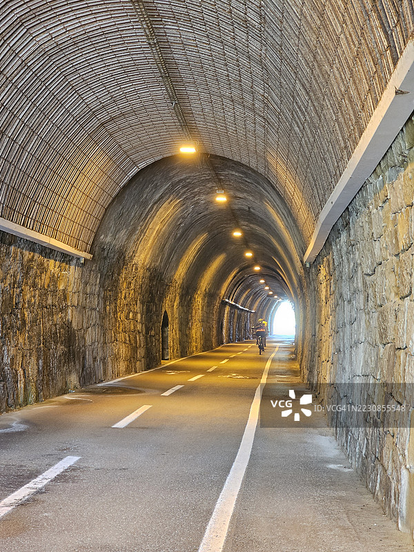 骑自行车的人穿过照明隧道，意大利圣雷莫图片素材