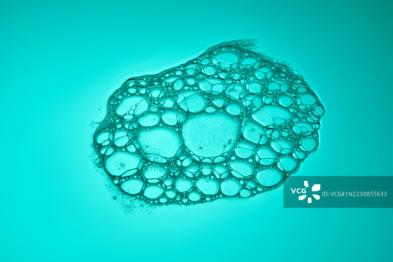 近距离拍摄的肥皂泡沫与青绿色背景图片素材